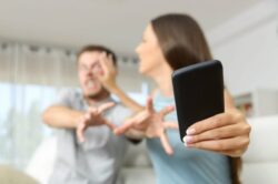 Sottrarre il telefono al partner per spiarne le conversazioni e cercare prova dell’infedeltà è reato?